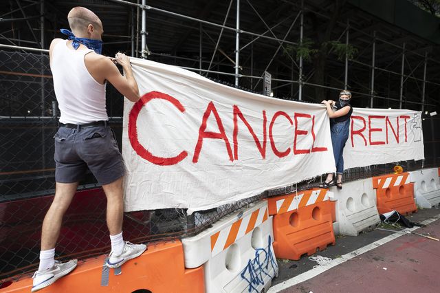 Activists hang a sign while participating in a protest calling on New York to cancel rent outside of Brooklyn housing court on August 6th, 2020.